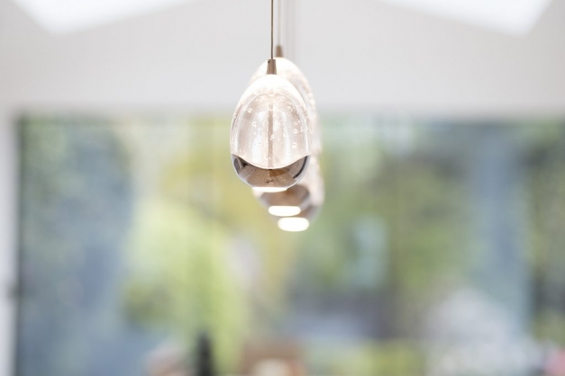 Glass lights hanging for the ceiling with the garden in the background